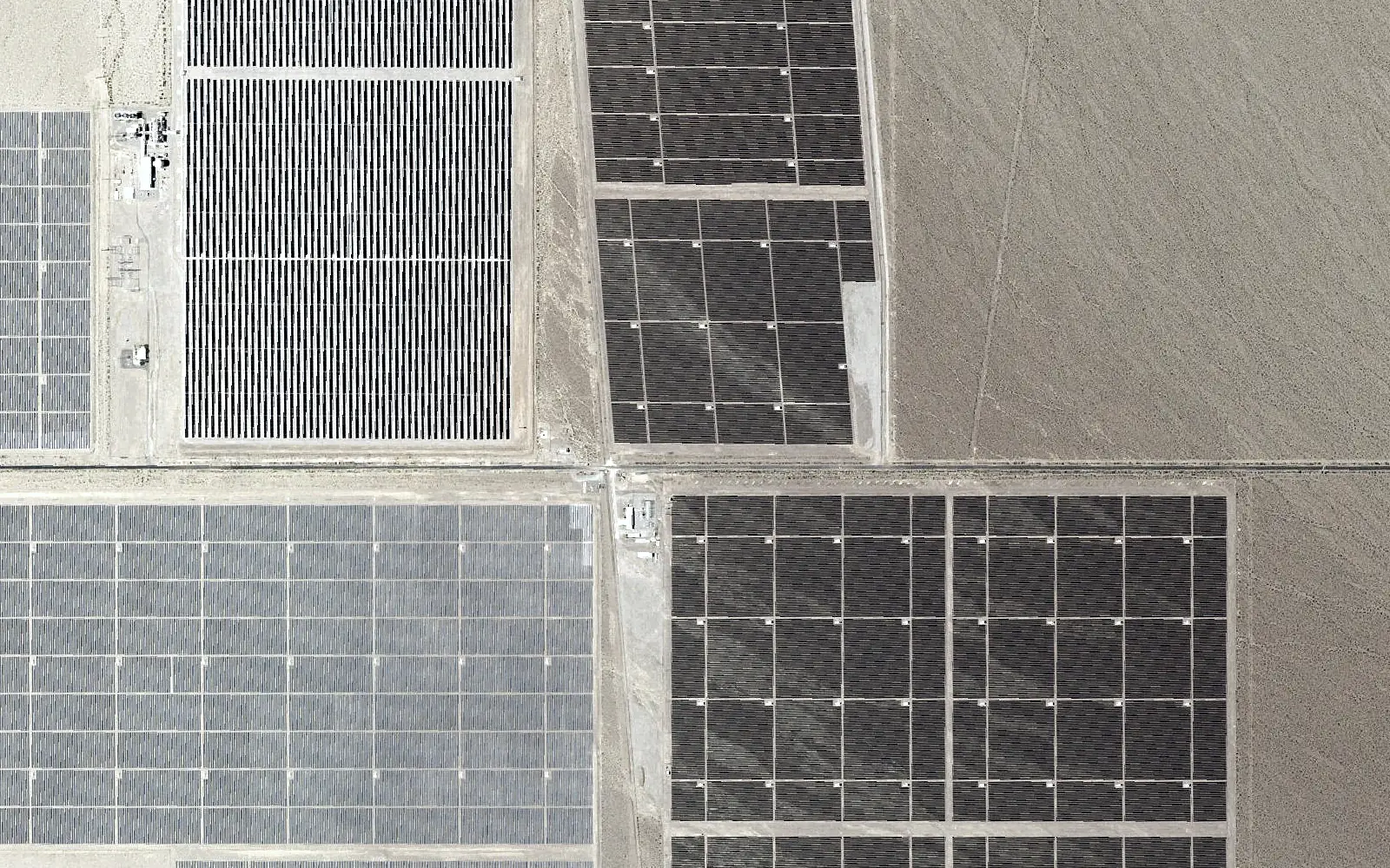 Aerial view: a substation yard among solar arrays.