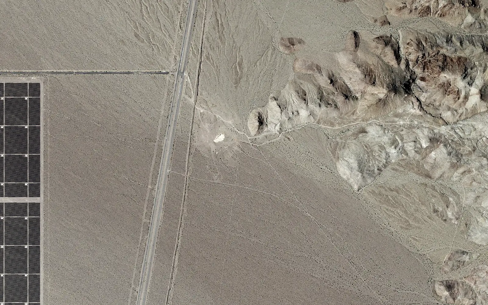 Aerial view: a transmission corridor crossing a desert valley.